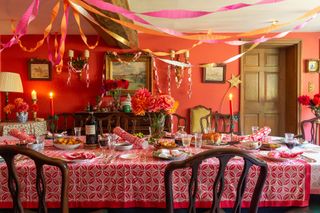 Christmas dining room with block printed Molly Mahon tablecloth, ceiling paper streamers and paper chains