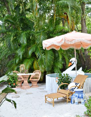 stock tank pool in a backyard with rattan lounger and fun tropical accessories