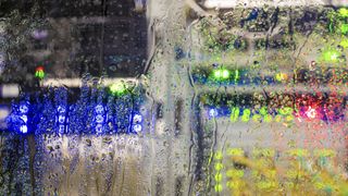 Image of a data center seen through glass with water dripping off it