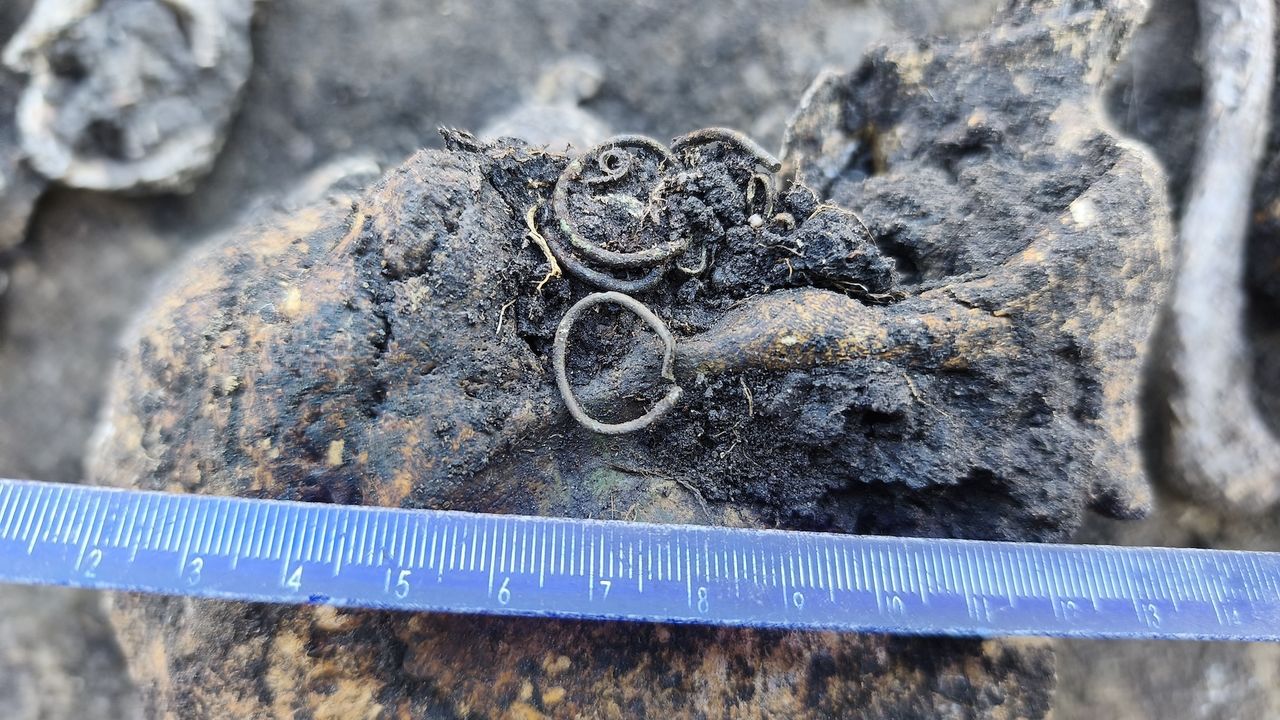 a close-up ofa weathered rings and beads in the dirt