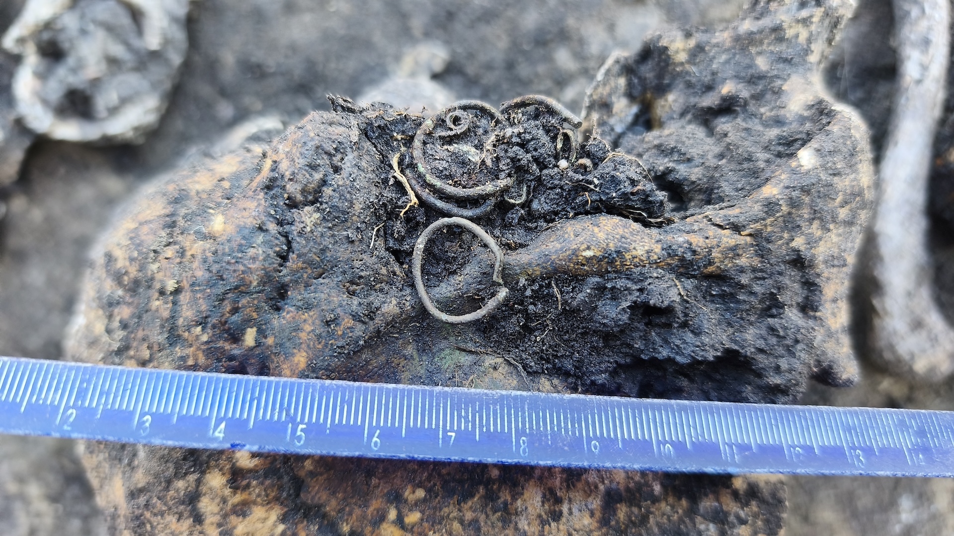a close-up ofa weathered rings and beads in the dirt