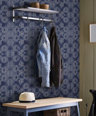 An indigo entryway with a coat hanger, coats, and an entryway bench