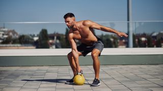 Man about to lift kettlebell from floor 