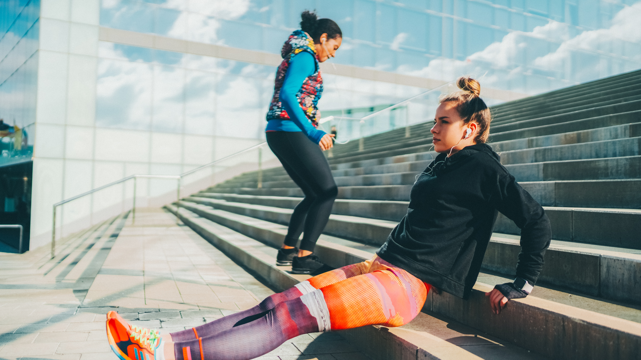 Two women exercising using steps