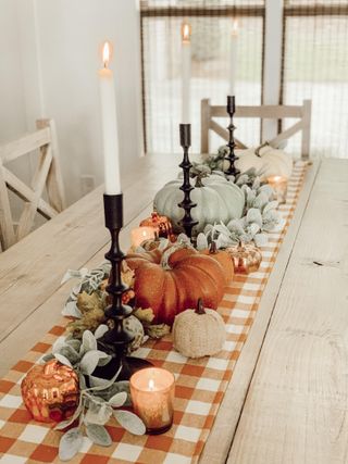 Fall tablescape with checked orange tablecloth and pumpkins