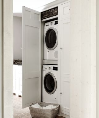 tall white cupboard with washing machine and tumble dryer stacked vertically