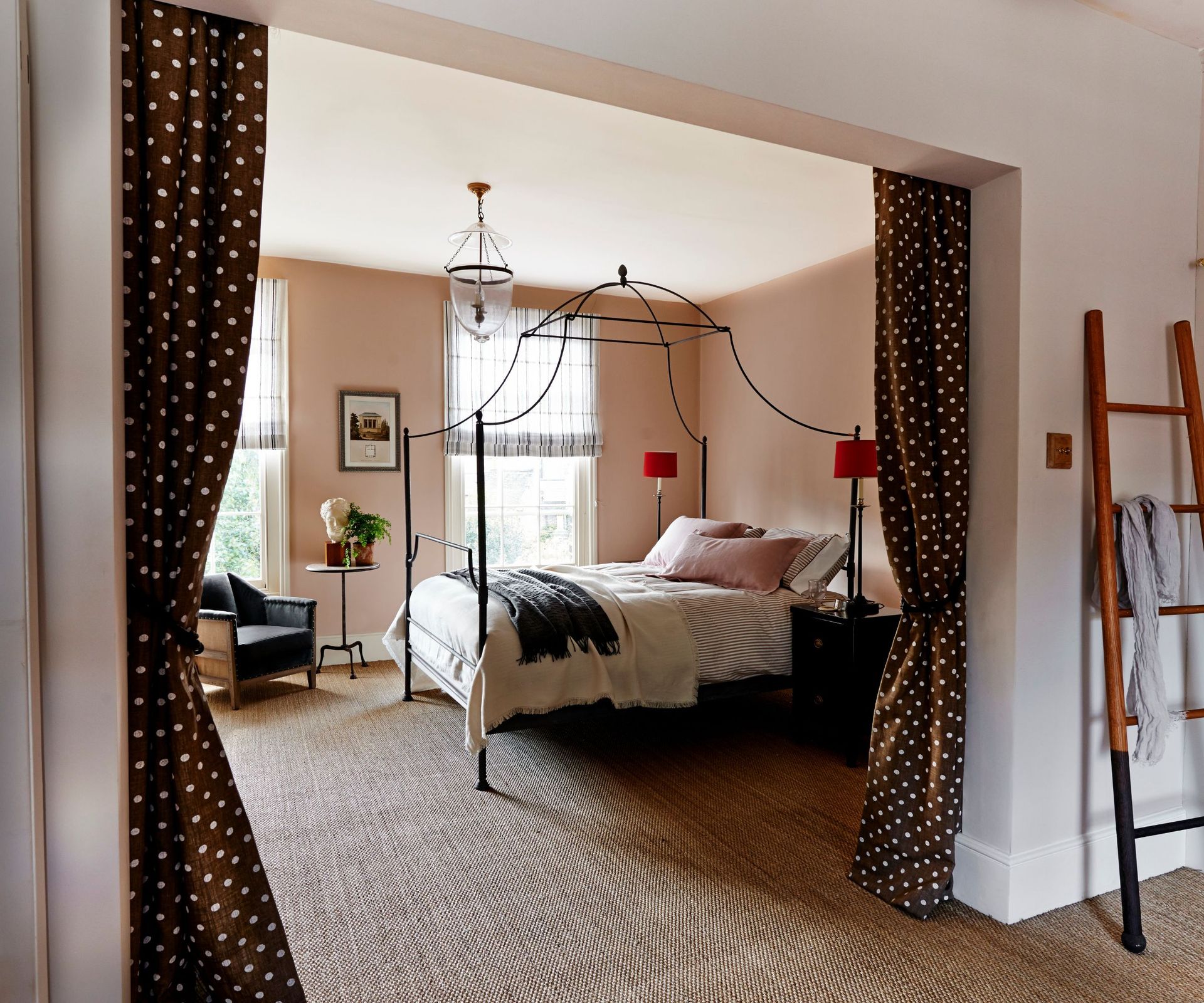 Bedroom with polka dot curtains, metal four posted frame and wooden ladder