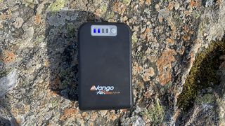 Vango powerbank on a rock showing 12V output with light showing how much charge is left