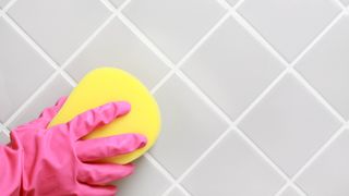 Cleaning tiles with yellow sponge