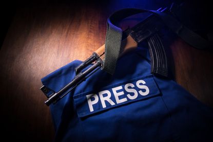Press vest wrapped around a rifle
