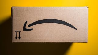 An upside down Amazon box against yellow background