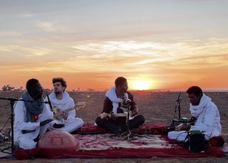 Mdou Moctar (second from right) performs with his band on the banks of the Niger River