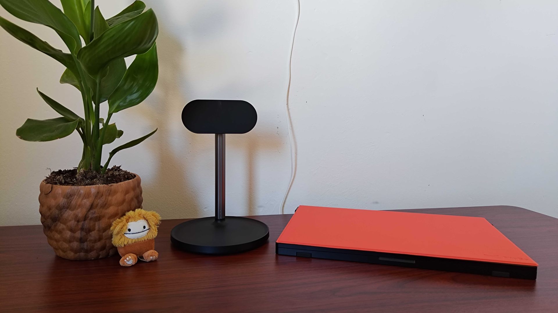 Jsaux FlipGo sitting on desk next to optional magnetic stand and plant