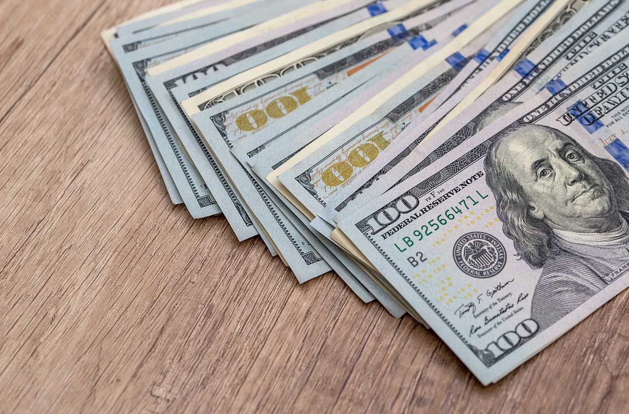 american dollar bills on wooden desk