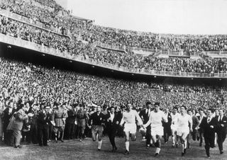 The Real Madrid made a lap of honour after its victory at the Champion Clubs' Europe Cup. One can recognize the players Alfredo DI STEFANO, MARQUITOS and MATEOS. The Real team won the Europe Cup for the second time by beating the Italian Fiorentina team by 2-0.