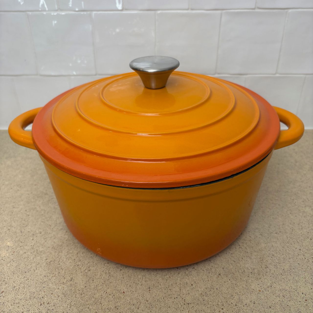 Orange cast iron pan on white countertop
