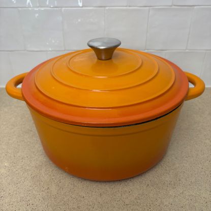 Orange cast iron pan on white countertop