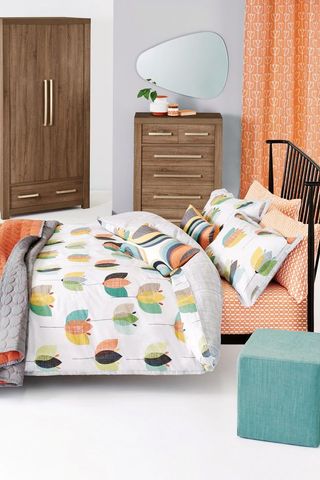 Cotton Rich Retro Tulip Bed Set in a white bedroom with dark brown wooden wardrobe and chest of drawers and a turquoise stool