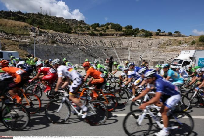 The riders buzz by a roman amphitheater