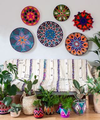 Bright and colorful Moroccan wool pots with plants, and woven wall plates.