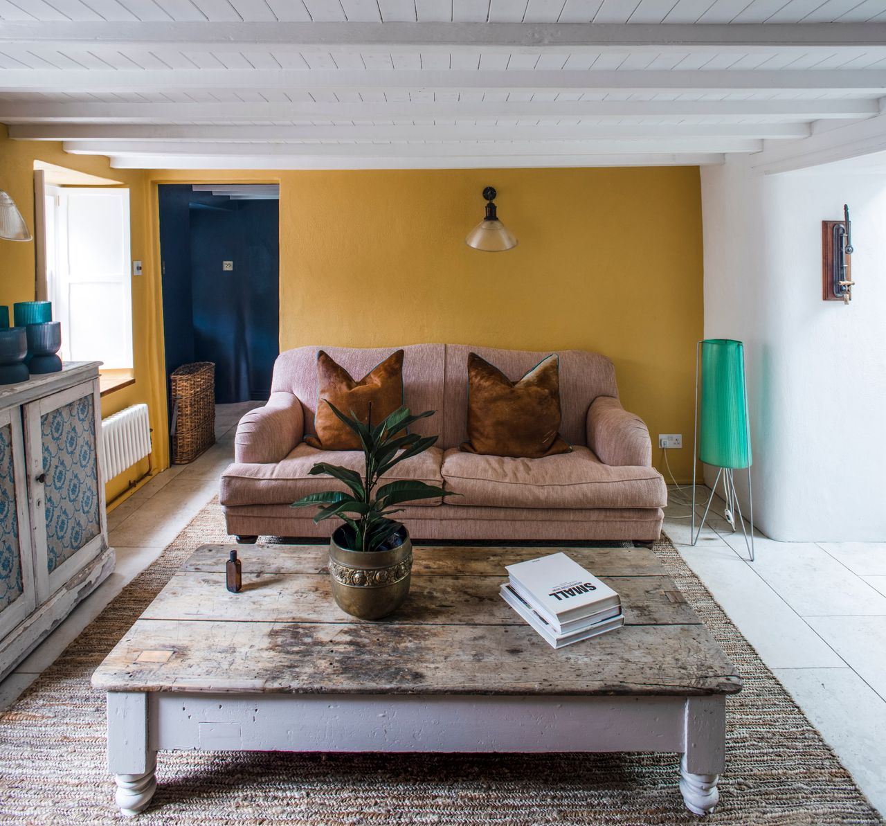 A cottage living room with yellow painted walls and reclaimed interiors