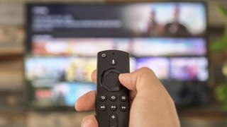 how to watch TV for free without cable, man holding a remote in front of a TV