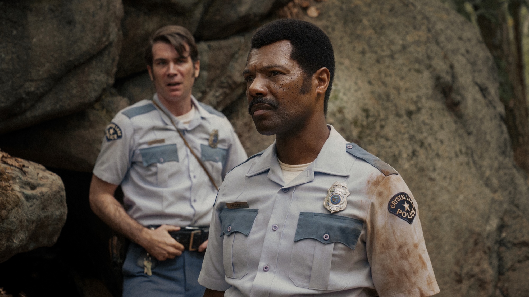 Officers Levon and Dorf standing near rock walls in Crystal Lake Season 1
