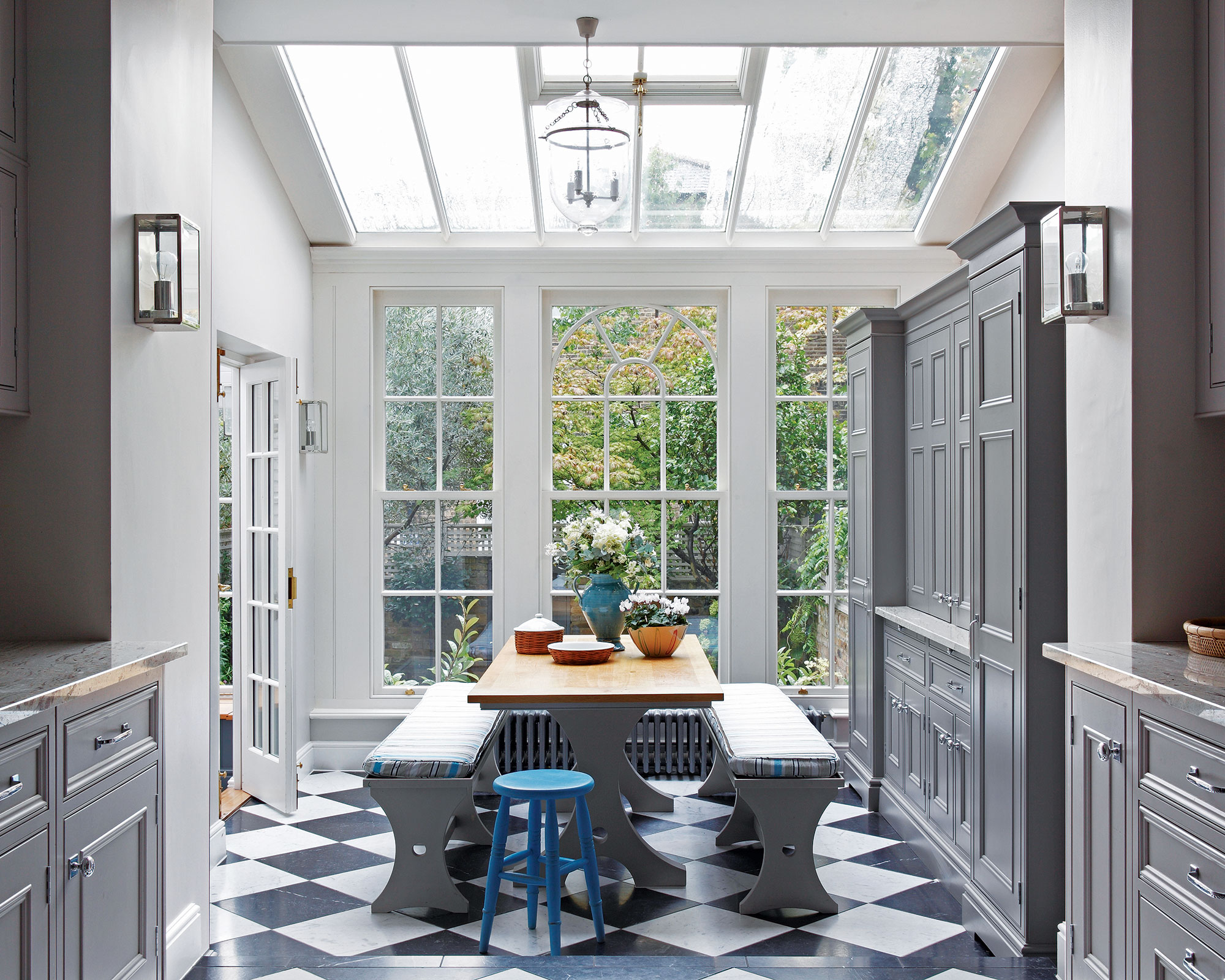 Gray kitchen cabinet colors with a skylight, large windows and dining area.