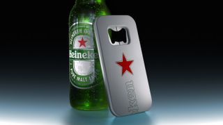 Heineken's 'The Closer' bottle opener leaning against a bottle of Heineken lager