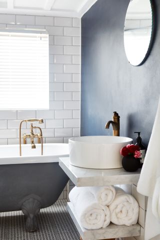 Bathroom with navy blue wall and marble sink with added storage