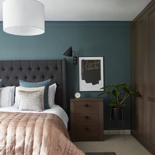 Teal bedroom with brown furniture