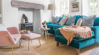 White living room with teal velvet sofa and log-burner