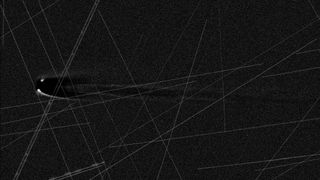 An image of a comet in black and white with lines streaking across the image. 