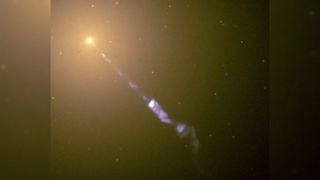 A giant jet of light shoots out from a distant galaxy in space