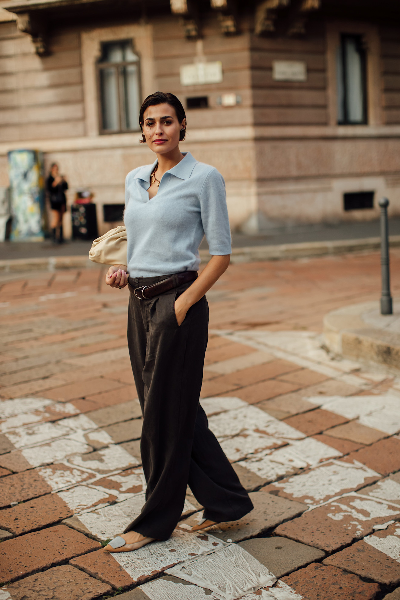 Woman in pale blue knit and brown trousers