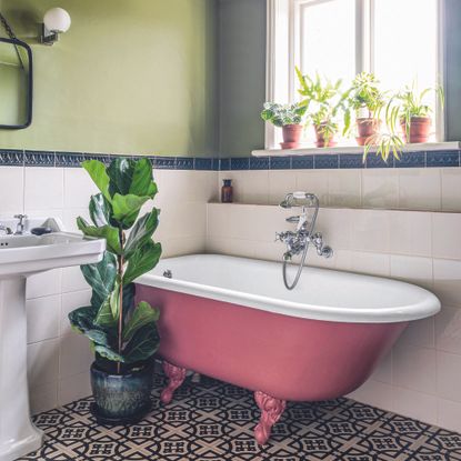 Pink bathroom in green bathroom with tiled floor.