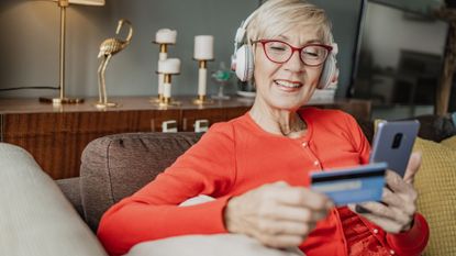 Woman shopping online at home via mobile phone