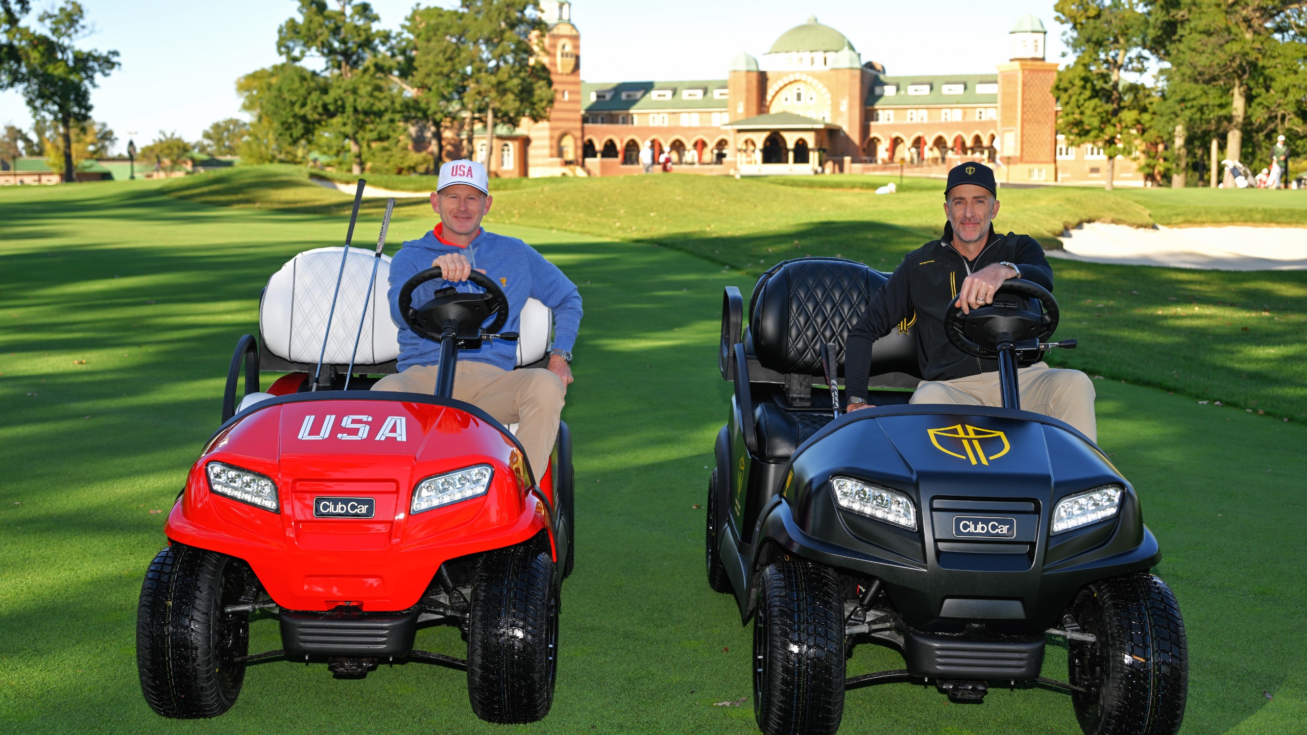 U.S. Team Captain, Brandt Snedeker, and International Team Captain, Geoff Ogilvy, sit in  golf carts in their team's livery during the Captains Day visit for the 2026 Presidents Cup at Medinah Country Club