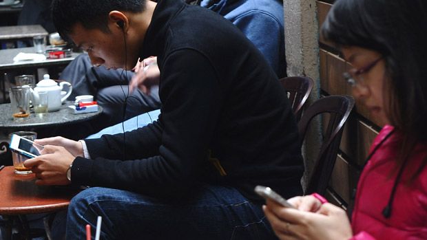 Customers use wireless devices at a coffee shop