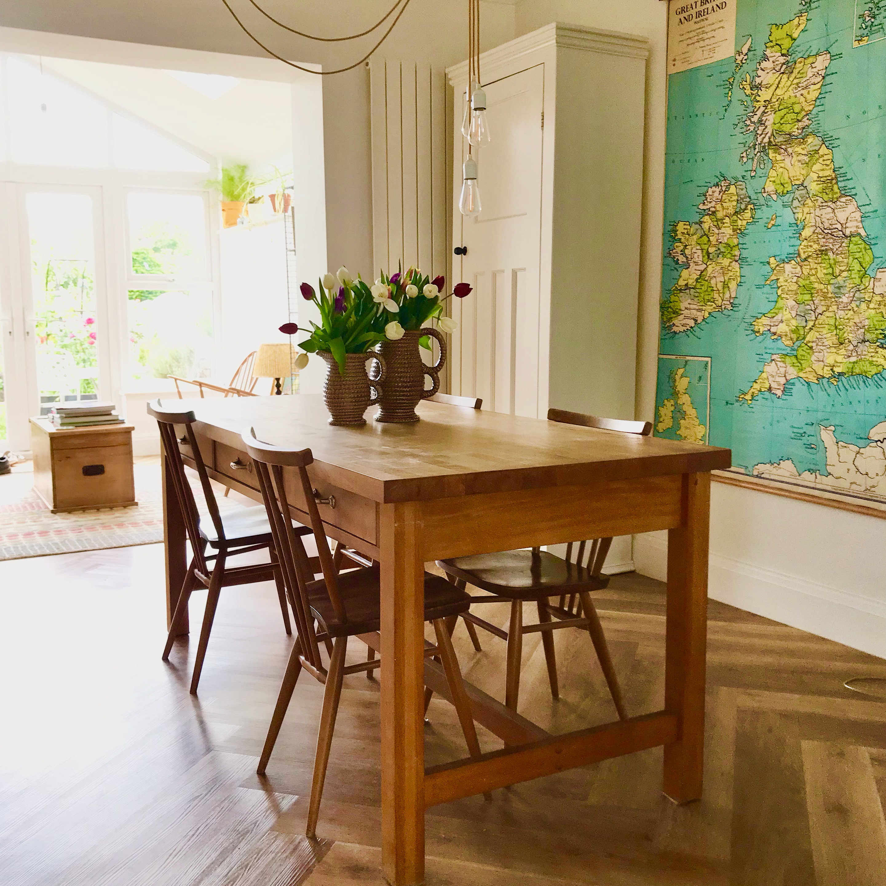 wood dining table with wood chairs and vintage jugs