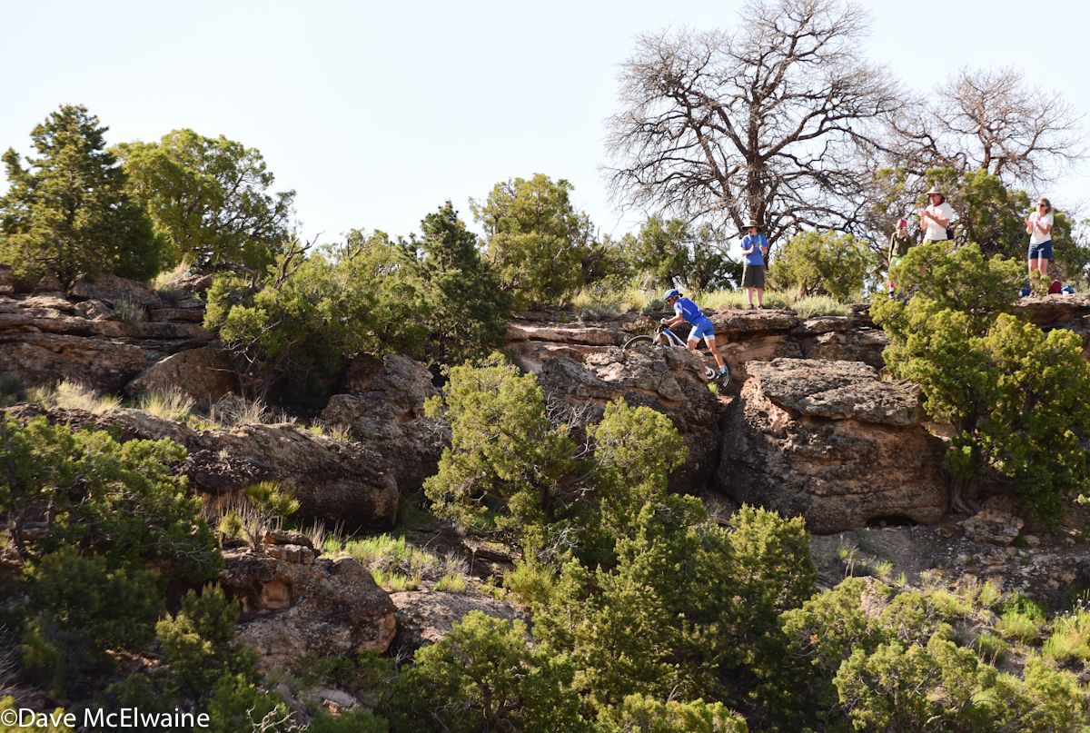 Katerina Nash (Luna Pro Team) pushing her bike to the top of a ridge while in first place
