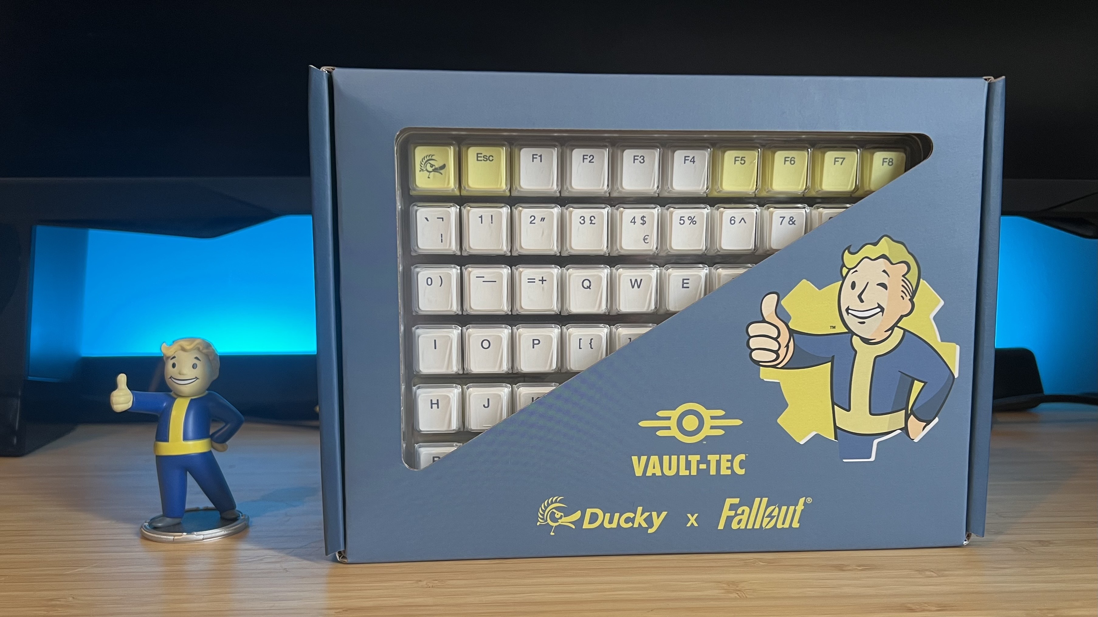 Ducky Fallout keycap set on a wooden desk with Pip Boy figure