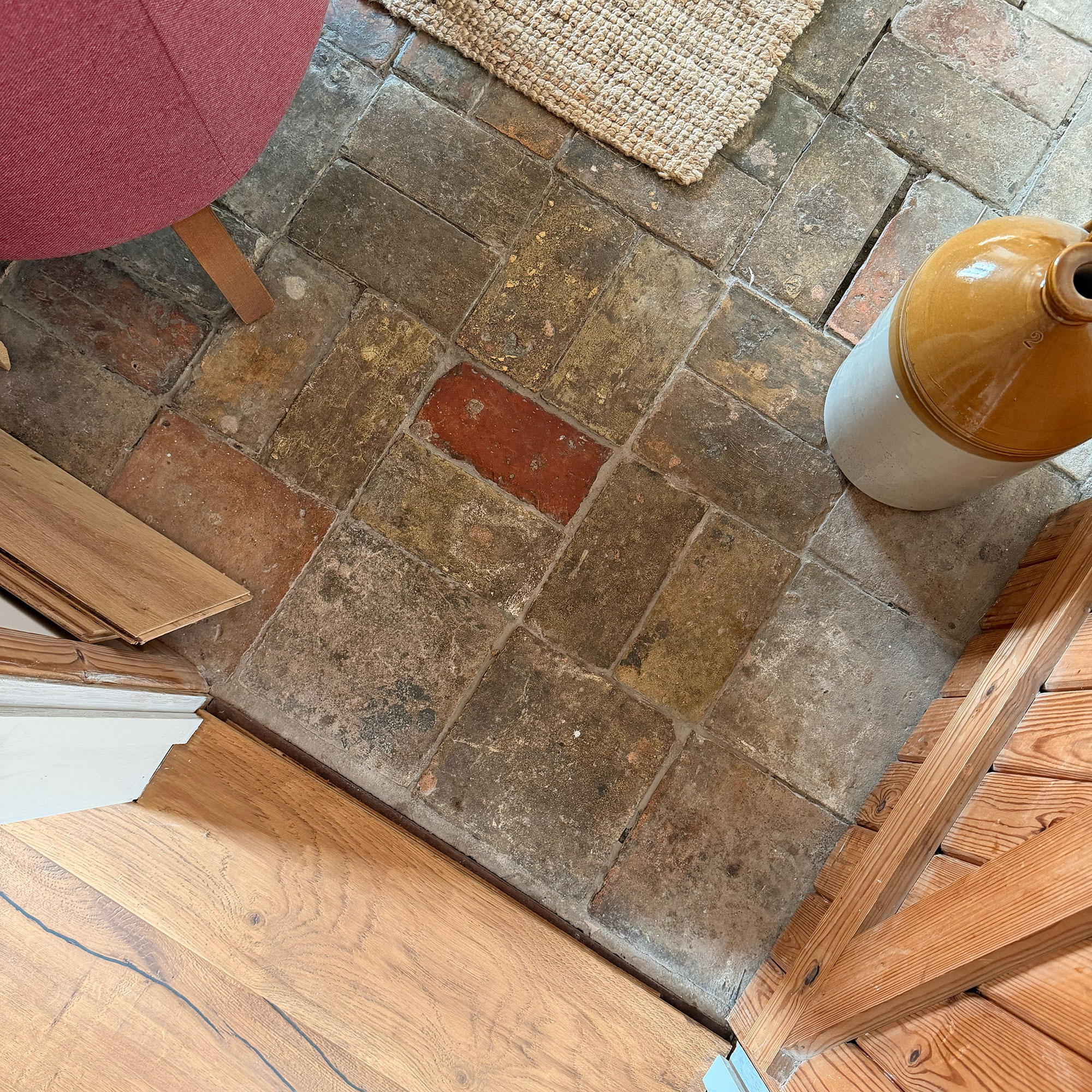 View from above of wooden flooring threshold meeting stone tiles