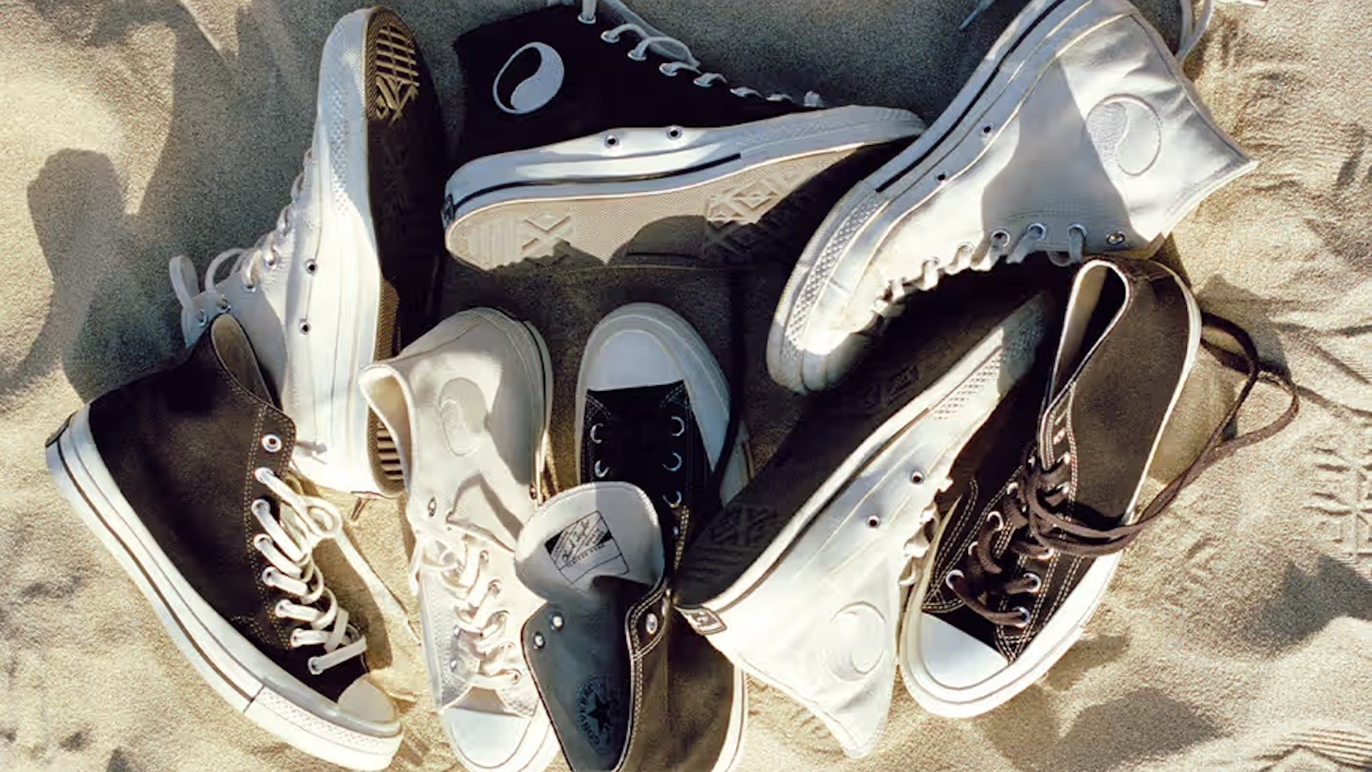 Our Legacy and Converse collab on a beach in a pile in multiple colours 