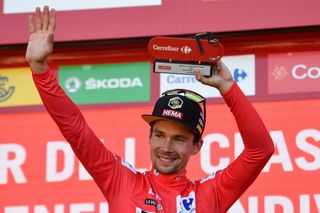 Team Jumbos Slovenian rider Primoz Roglic celebrates on the podium holding the trophy and wearing the overall leaders red jersey after winning the 4th stage of the 2022 La Vuelta cycling tour of Spain a 1525 km race from VitoriaGasteiz to Laguardia on August 23 2022 Photo by ANDER GILLENEA AFP Photo by ANDER GILLENEAAFP via Getty Images