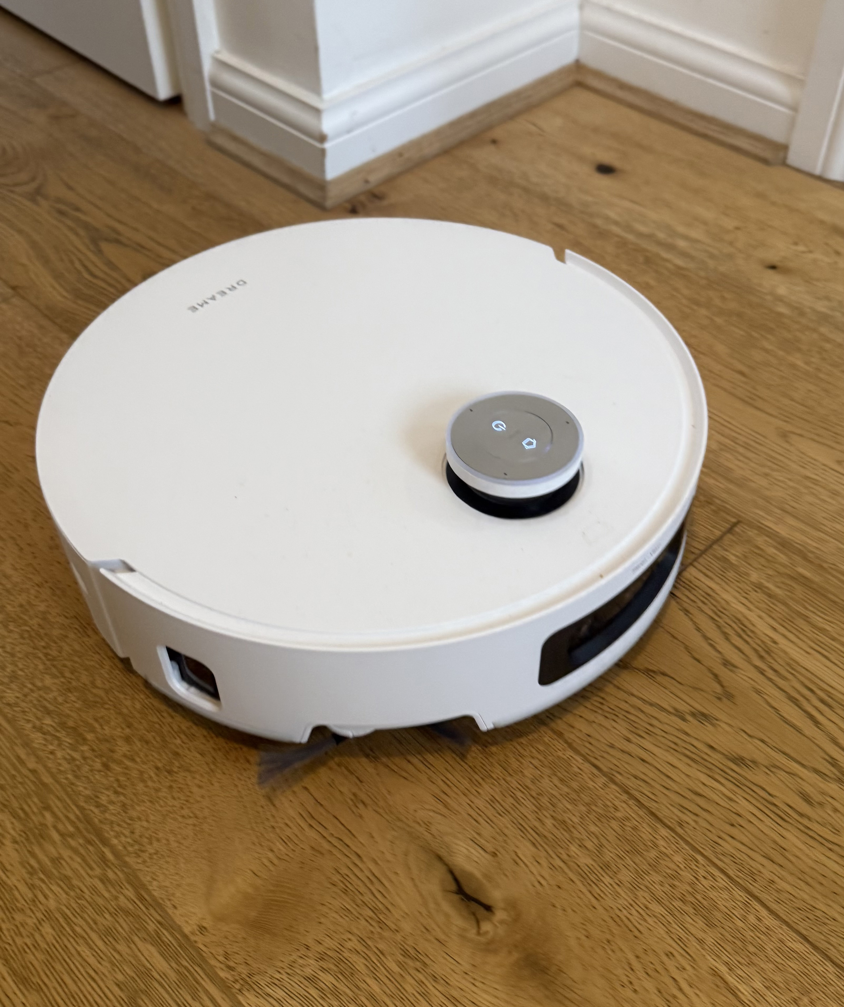 Close-up of the Dreame Aqua10 Ultra Roller robot vacuum showing its built-in navigation and sensor module