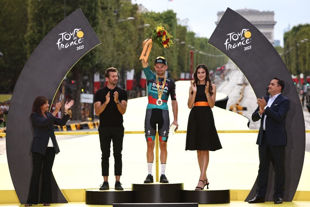 Mayor of Paris Anne Hidalgo L applauds as BORA hansgrohes Belgian rider Jordi Meeus celebrates his victory on the podium after winning the 21st and final stage of the 110th edition of the Tour de France cycling race 115 km between SaintQuentinenYvelines and the ChampsElysees in Paris on July 23 2023 Photo by AnneChristine POUJOULAT AFP Photo by ANNECHRISTINE POUJOULATAFP via Getty Images