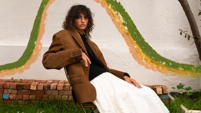 An image of a model wearing a blazer, jumper and full skirt for an autumn winter trend fashion story