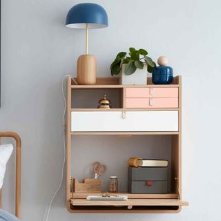 white wall with attached desk shelves and lamp