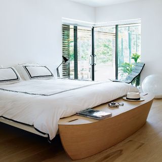 bedroom with white wall and white bad on wooden floor